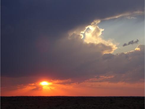 夕陽の右から迫る厚い雷雲