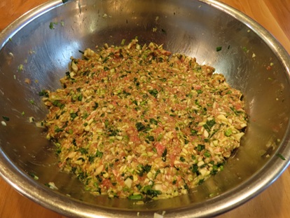 大きなボウルの中で合い挽きひき肉と細かな野菜、調味料が均一に混ぜ合わさって粘り気が出た餃子の餡（あん）